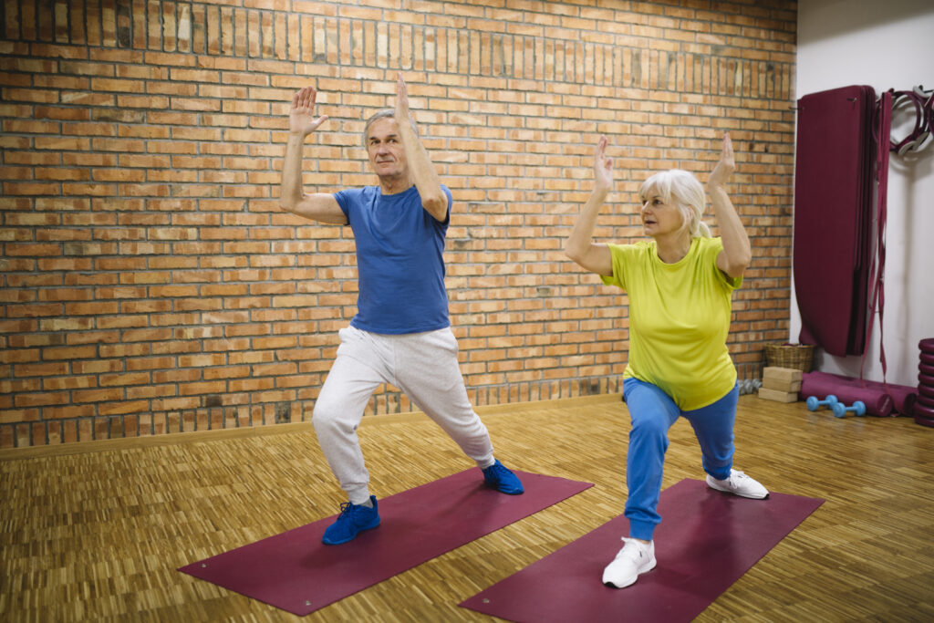 Elderly gentleman and elderly woman participating in Tai Chi